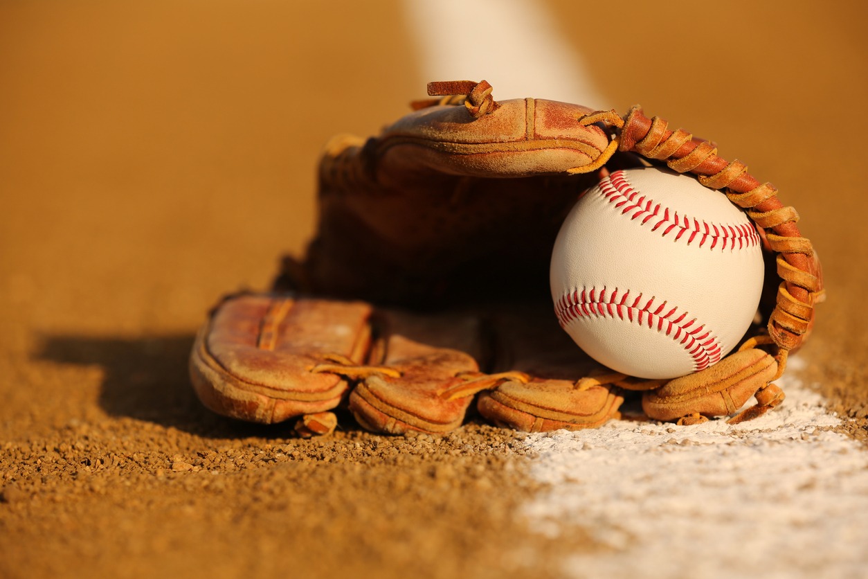 A baseball glove with a ball on the field