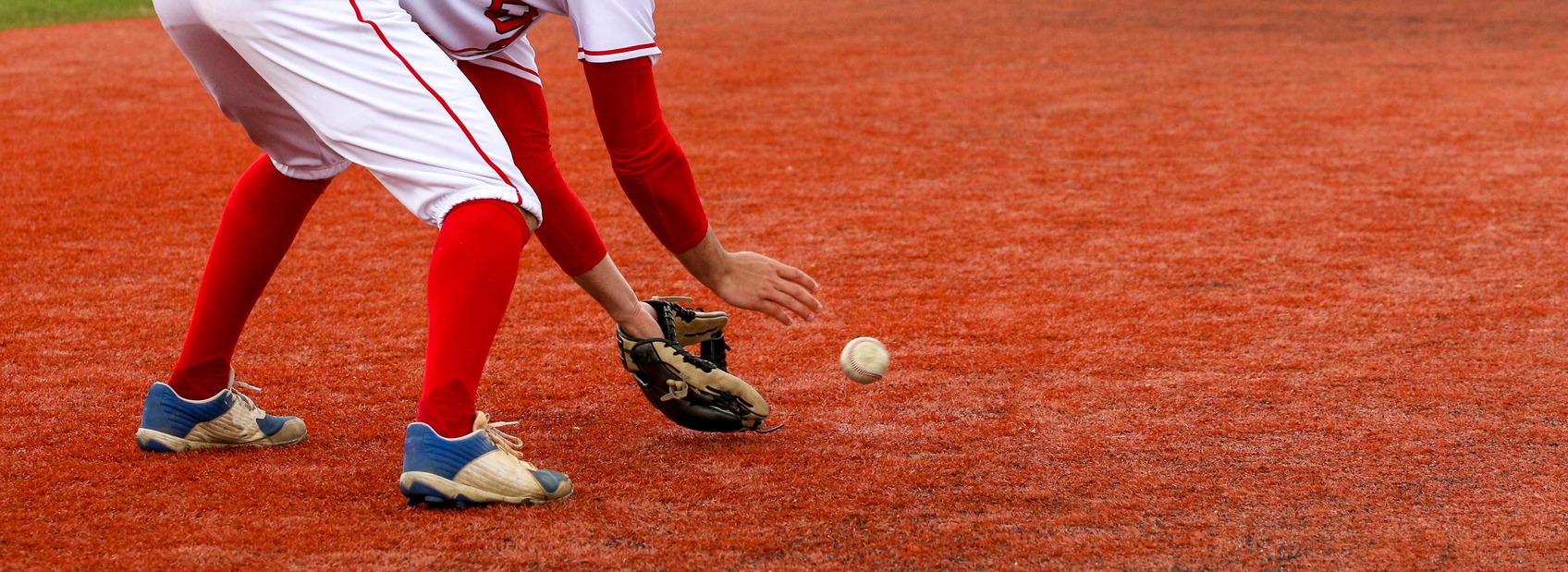 A baseball infielder fielding the ball