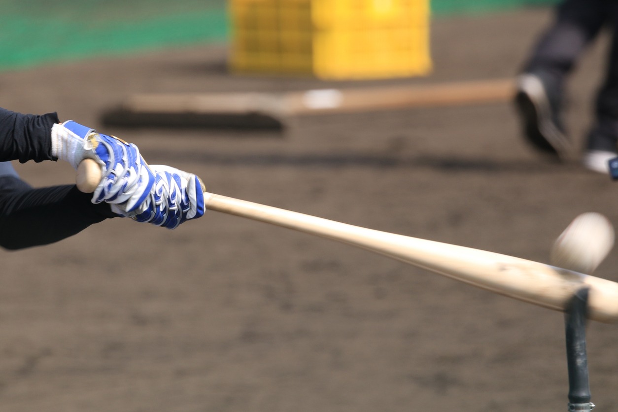 baseball on top of a batting tee being hit