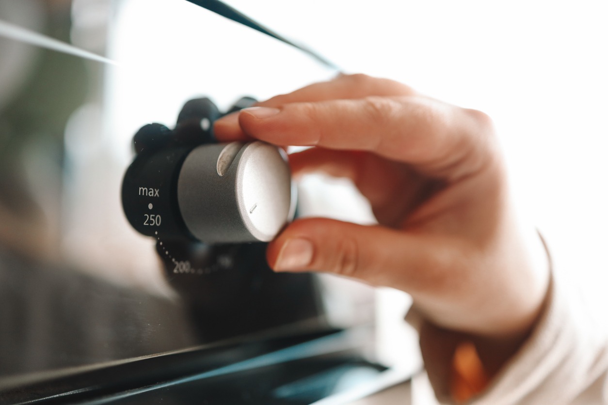 A person turning on the oven