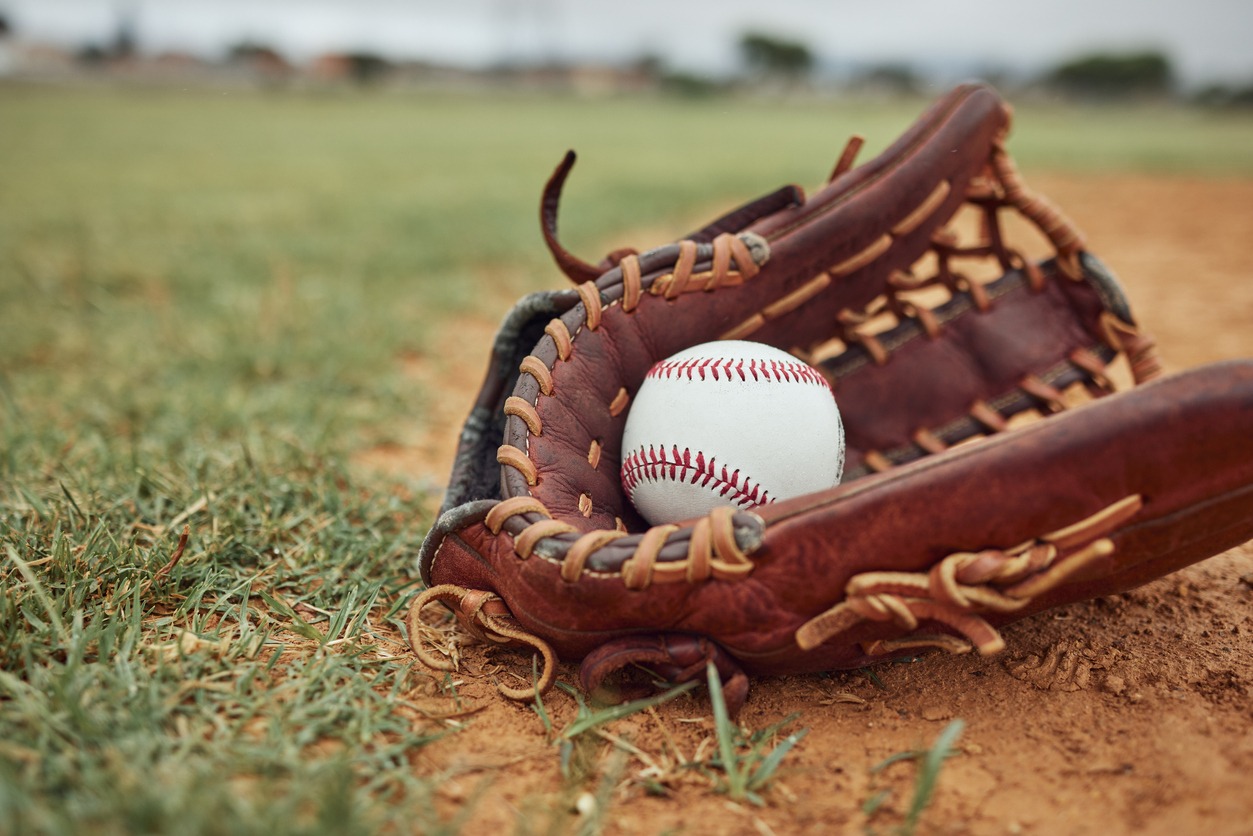 A baseball glove and ball on the ground